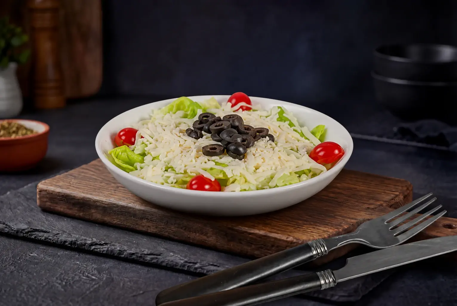 Cheese salad with shredded lettuce, shredded cheese, cherry tomatoes and black olives